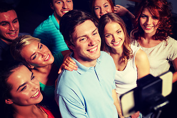 Image showing friends with smartphone taking selfie in club