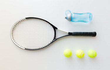 Image showing close up of tennis racket with balls and bottle