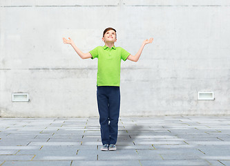 Image showing happy boy in polo t-shirt raising hands up