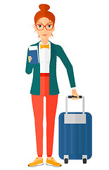 Image showing Woman standing with suitcase and holding ticket.