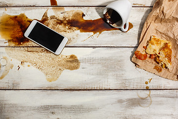 Image showing Cup of coffee spilled on wooden table