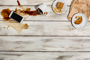 Image showing Cup of coffee spilled on wooden table