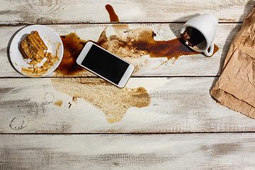 Image showing Cup of coffee spilled on wooden table