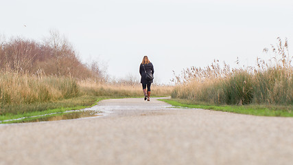 Image showing Young woman walking in a dutch landscape