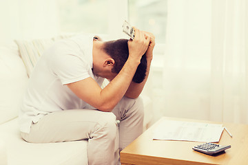 Image showing man with money and calculator at home