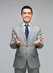 Image showing happy businessman in suit showing empty palms