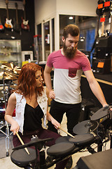 Image showing man and woman with drum kit at music store