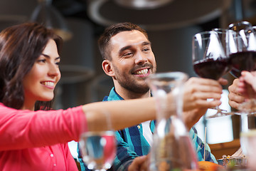 Image showing friends clinking glasses of wine at restaurant