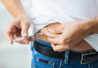 Image showing man with syringe making insulin injection