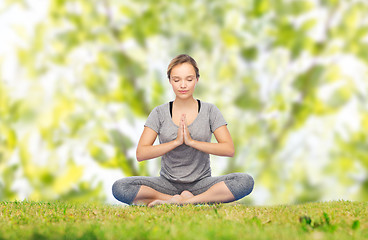 Image showing woman making yoga meditation in lotus pose on mat