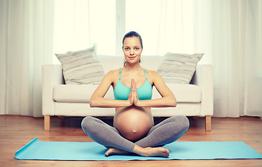 Image showing happy pregnant woman meditating at home