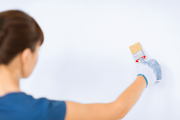 Image showing woman with paintbrush colouring the wall