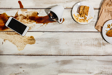 Image showing Cup of coffee spilled on wooden table