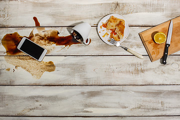 Image showing Cup of coffee spilled on wooden table