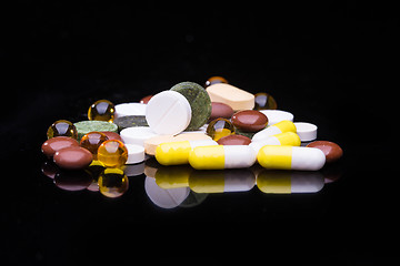 Image showing Pile of various colorful pills isolated on black