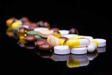 Image showing Pile of various colorful pills isolated on black