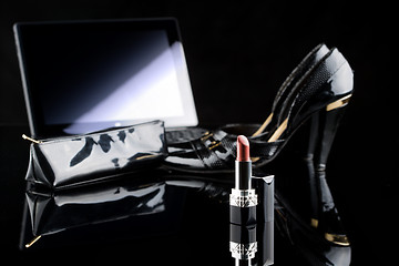 Image showing laptop, lipstick and shoes. black background. female set. Online buying cosmetics