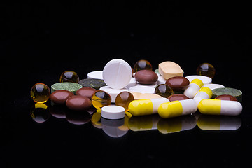 Image showing Pile of various colorful pills isolated on black