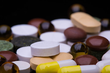 Image showing Pile of various colorful pills isolated on black