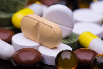 Image showing Pile of various colorful pills isolated on black