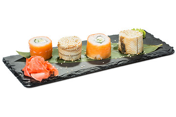 Image showing set of sushi on black slate substrate, isolated white background