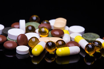 Image showing Pile of various colorful pills isolated on black