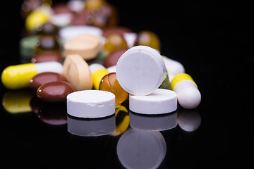 Image showing Pile of various colorful pills isolated on black