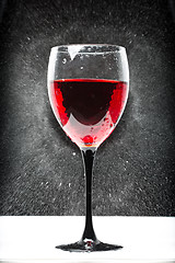 Image showing glass with red wine. splashing water