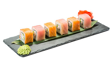 Image showing set of sushi on black slate substrate, isolated white background