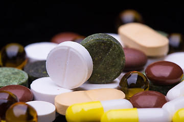 Image showing Pile of various colorful pills isolated on black