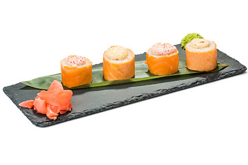 Image showing set of sushi on black slate substrate, isolated white background