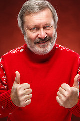 Image showing Elderly man showing ok sigh on a red background