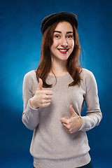 Image showing The young girl showing  the ok thumbs up hand sign