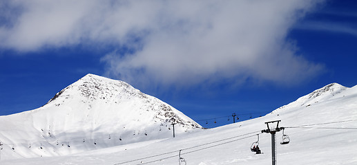 Image showing Panoramic view on chair-lift and ski slope at sun day