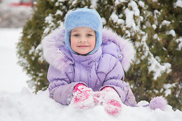 Image showing Girl lying in the snow and the snow smiling