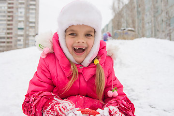 Image showing The girl rolled down a hill and looking happily into the frame