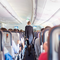 Image showing Stewardess and passengers on commercial airplane.