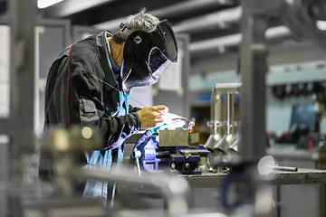 Image showing Industrial worker welding in metal factory.