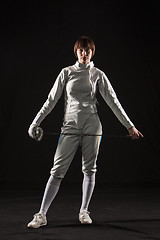 Image showing The portrait of woman wearing white fencing costume  on black 