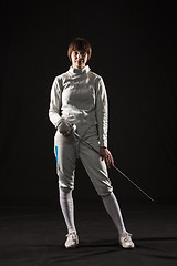 Image showing The portrait of woman wearing white fencing costume  on black 