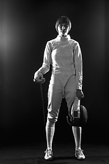 Image showing The portrait of woman wearing white fencing costume  on black 