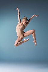 Image showing Young beautiful modern style dancer jumping on a studio background