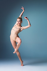 Image showing Young beautiful modern style dancer jumping on a studio background