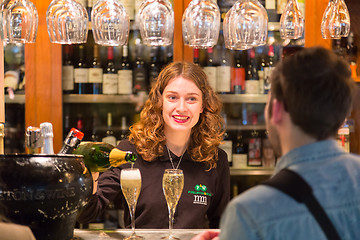 Image showing Waitress serving champagne at San Miguel market, Madrid.