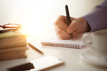 Image showing The male hand with a pen and the cup