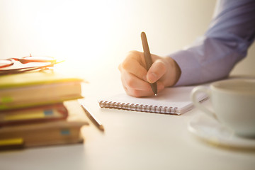 Image showing The male hand with a pen and the cup