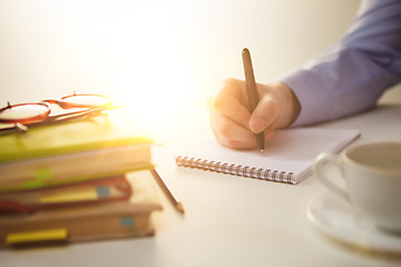 Image showing The male hand with a pen and the cup