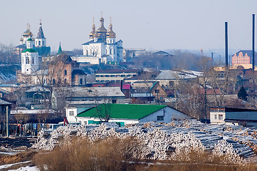 Image showing Big pile of logs and two churches. Tyumen. Russia