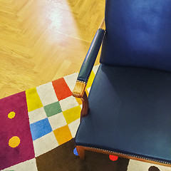 Image showing Blue leather armchair on colorful rug