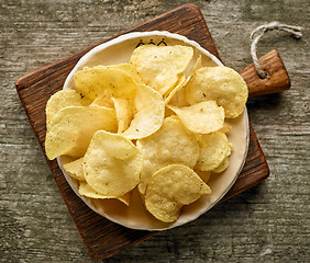 Image showing potato chips on wooden table